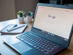 chromebook sitting on a desk with google.com on the screen