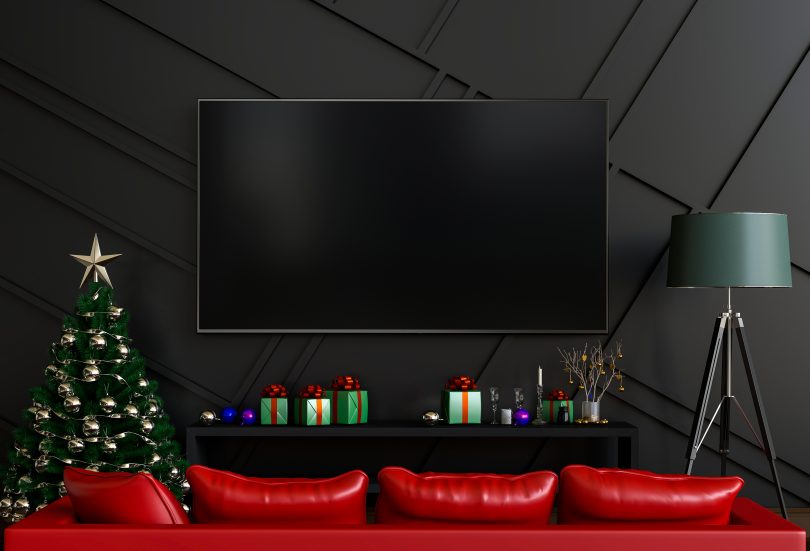 red couch in front of hanging tv on wall