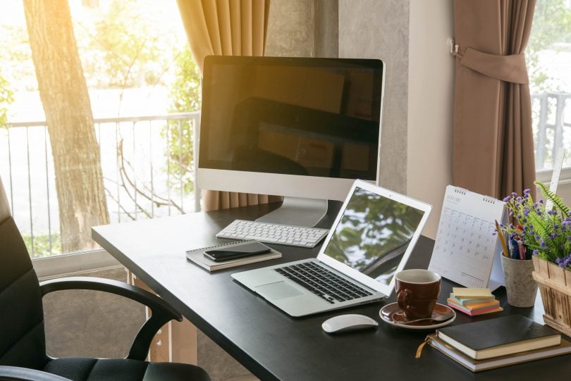 desktop and laptop sitting on office desk