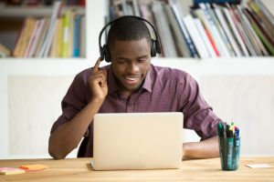 office worker listening to headphones while working on computer