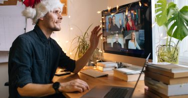 young working professional video conferencing with coworkers during the holidays