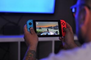 tattooed man playing Nintendo switch