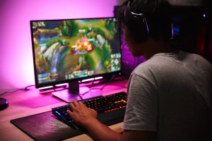 young man playing PC games in his room