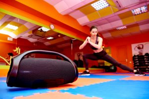 woman working out at home with portable speaker