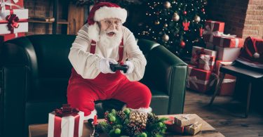 Santa sitting on the couch and playing video games