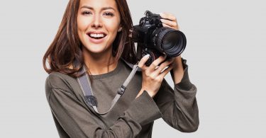 Woman photographer taking photos with DSLR camera