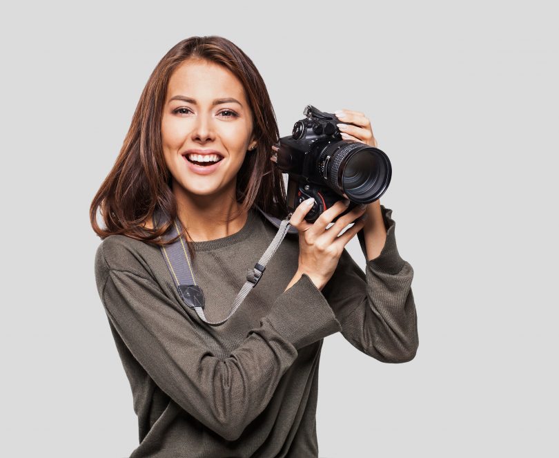 Woman photographer taking photos with DSLR camera