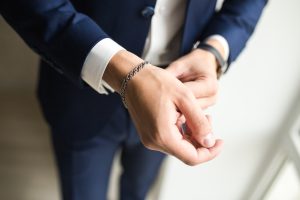 business man putting on silver bracelet on his wrist