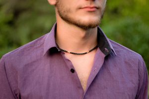 man outside wearing black necklace