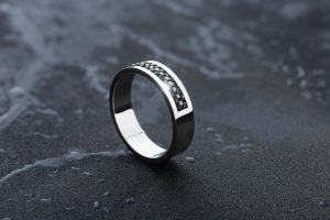 titanium ring standing on its side on a marble counter