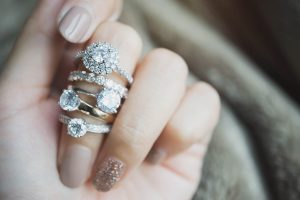 woman admiring several rings on her hand