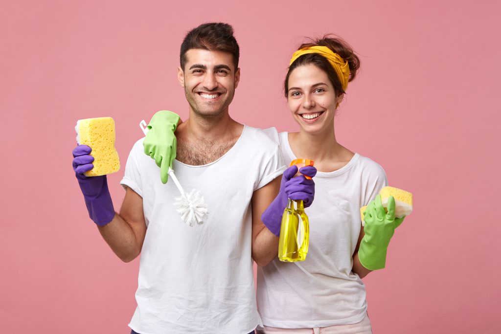 male and female smiling and posing with cleaning products