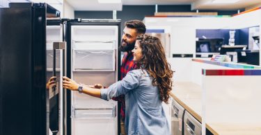 young suburban couple shopping for a new refrigerator