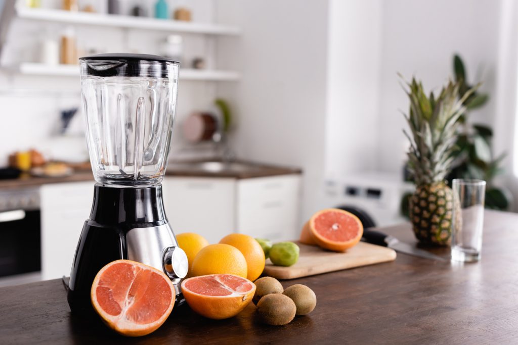 fruits on kitchen counter next to a blender