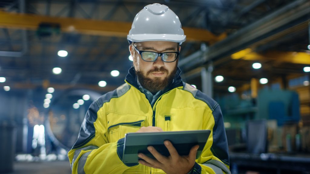 factory worker using tablet to view blueprints