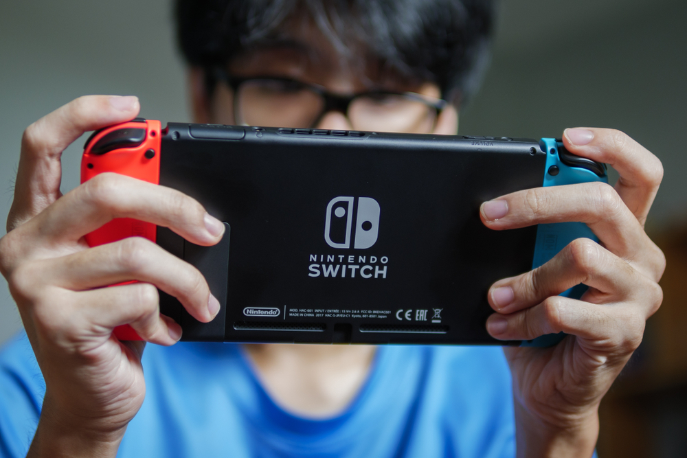 Young man playing Nintendo Switch at home