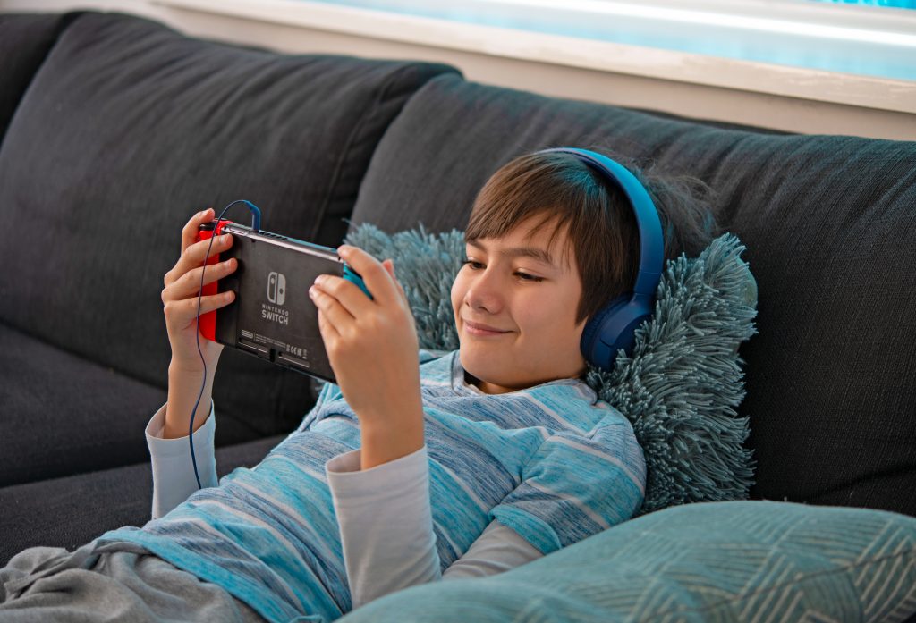 young man playing nintendo switch at home