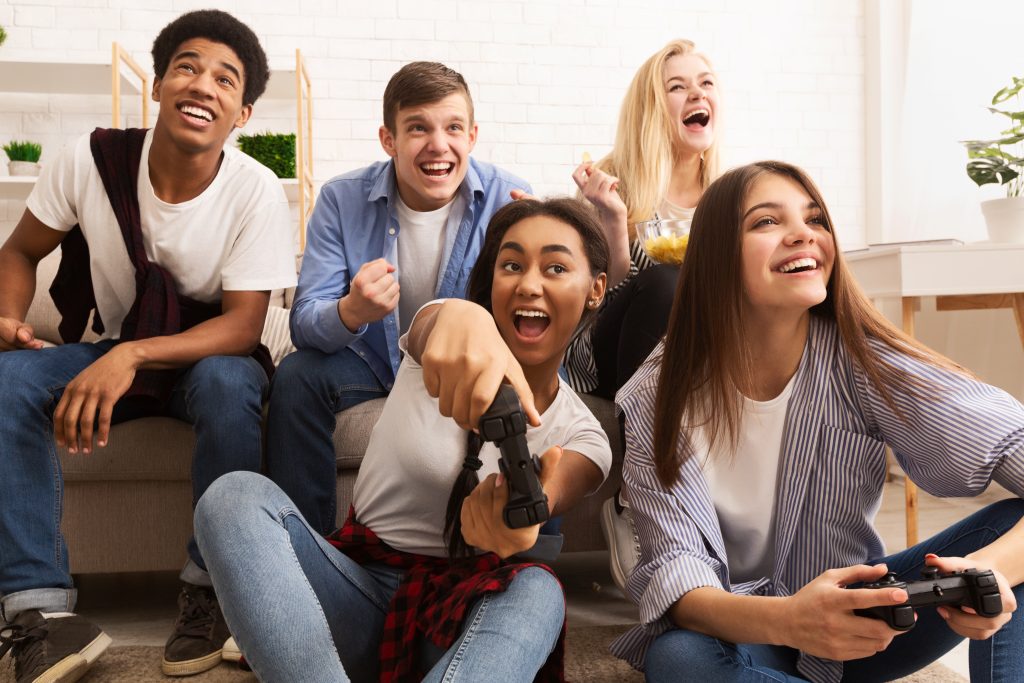 Diverse group of college students gaming and laughing