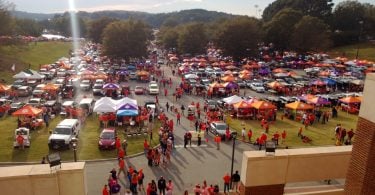 Wide aerial shot of hundreds of game day tailgaters set up on morning of game