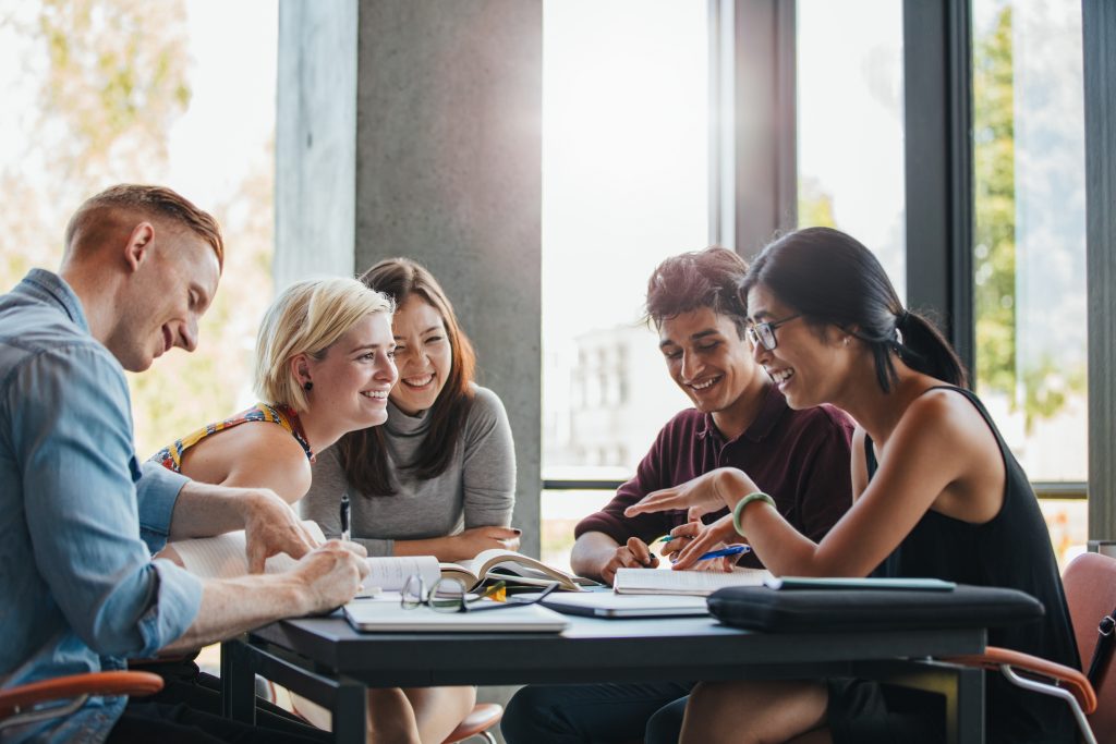 Group of happy diverse college students studying together