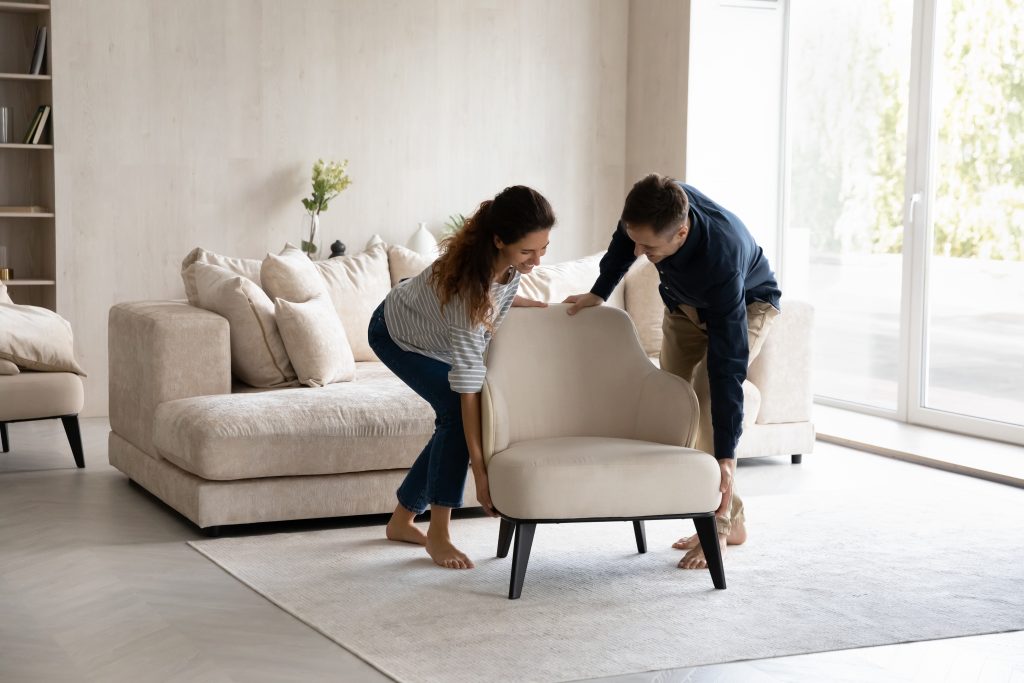 Young couple getting new furniture, moving chair