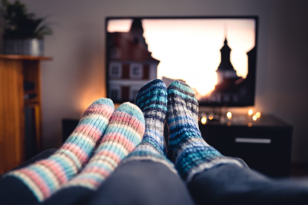 Shot of cozy, socked feet propped up in front of TV