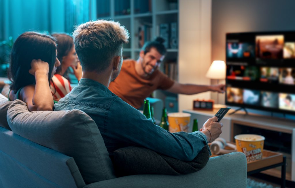 Two couples gathered around TV deciding what to stream